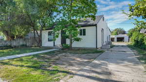View of front of property with concrete driveway, garage in the back.