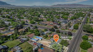Aerial view of property and surrounding area with property boundaries highlighted, a mountainous background, and nearby suburban area