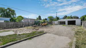 View of yard featuring a detached garage and an outbuilding