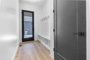 Mudroom with light wood-style flooring and baseboards