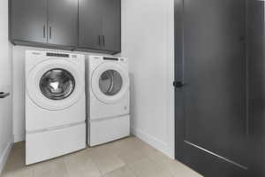 Laundry room with cabinet space, separate washer and dryer, and light tile patterned floors