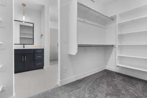 Walk in closet with a sink and carpet floors