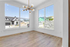 Empty room featuring a chandelier and wood finished floors