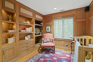 Living area featuring light wood-style flooring, built in shelves, and recessed lighting