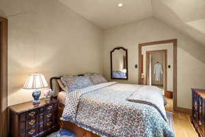 Bedroom featuring vaulted ceiling and wood finished floors