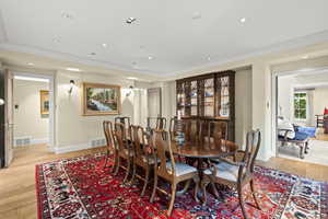Dining space featuring ornamental molding, light wood-style flooring, and recessed lighting