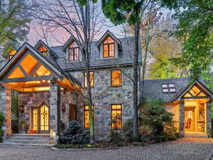 View of front of property with stone siding and a high end roof