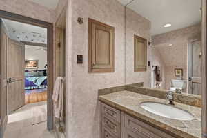 Full bathroom featuring connected bathroom, vanity, a ceiling fan, and a shower stall