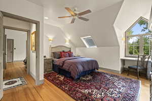 Bedroom featuring vaulted ceiling, light wood-type flooring, and a ceiling fan