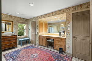 Bathroom with wallpapered walls, vanity, tile patterned floors, and recessed lighting