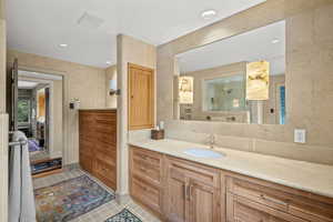 Bathroom with vanity, tile patterned flooring, and recessed lighting
