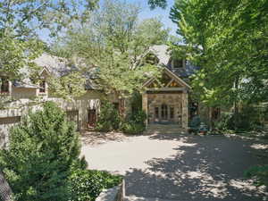 View of front of property with driveway and stone siding