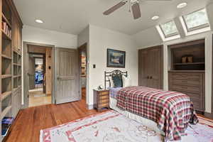 Bedroom featuring a skylight, light wood-style flooring, ceiling fan, recessed lighting, and vaulted ceiling