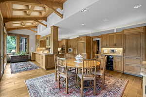 Dining area featuring wine cooler, light wood finished floors, wood ceiling, and recessed lighting