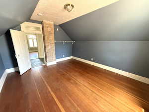 Bonus room with hardwood / wood-style floors and vaulted ceiling