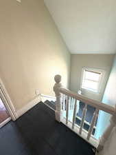 Stairs featuring a textured wall and hardwood / wood-style floors