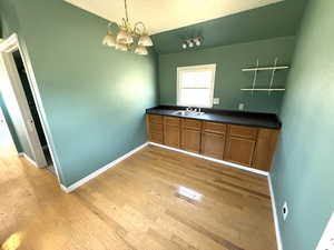 Unfurnished dining area with light wood-style flooring and a chandelier