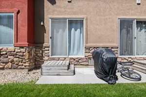 Entrance to property featuring stone siding and stucco siding