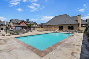 Community pool with a patio area and a residential view