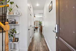 Corridor with wood finished floors and stairway