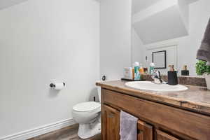 Half bathroom featuring vanity and wood finished floors