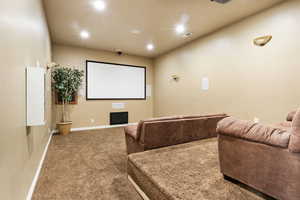 Carpeted home theater with recessed lighting and baseboards