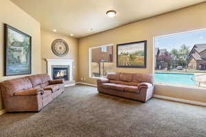 Carpeted living room featuring plenty of natural light, a fireplace, and recessed lighting