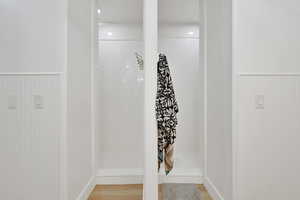 Detailed view of wainscoting and wood finished floors with twin showers