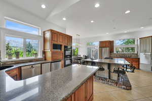 Kitchen featuring black appliances, decorative backsplash, recessed lighting, dark stone counters, and light tile patterned floors