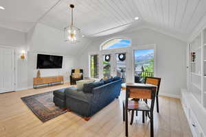 ADU Living area featuring lofted ceiling, light wood finished floors, a chandelier, and recessed lighting
