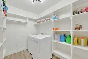Laundry area featuring light wood finished floors and washing machine and dryer