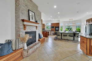 Living room with recessed lighting, light tile patterned floors, and a brick fireplace