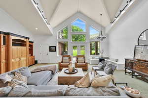 Living area featuring light colored carpet and high vaulted ceiling