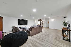Living area featuring stairway, light wood-type flooring, and recessed lighting