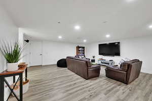 Living area with light wood-style flooring and recessed lighting