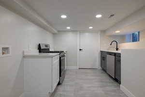 Kitchen with stainless steel appliances, recessed lighting, and light countertops