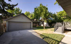 View of front of house featuring an outdoor structure, a detached garage, and a deck