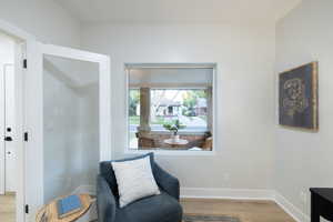 Sitting room with wood finished floors and baseboards
