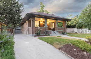 View of front of house featuring brick siding, an outdoor structure, and a detached garage