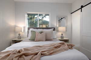 Bedroom featuring a barn door and carpet