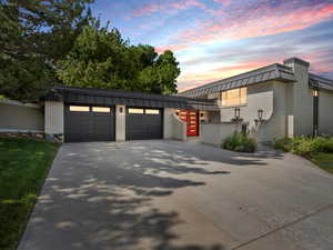 View of front of house featuring a garage, brick siding, and driveway