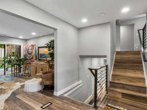 Stairway with hardwood / wood-style floors and recessed lighting