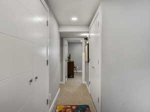 Hall with light carpet and recessed lighting