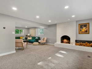 Living area with recessed lighting, carpet floors, and a fireplace