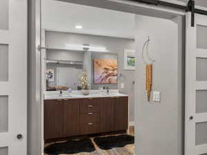 Full bathroom with double vanity, wood finished floors, and recessed lighting