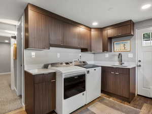 Kitchen with washing machine and clothes dryer, light countertops, light wood-style floors, and recessed lighting