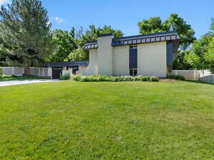 View of side of home with brick siding, a garage, concrete driveway, and a standing seam roof