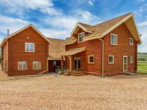 Back of house with a shingled roof and a mountain view