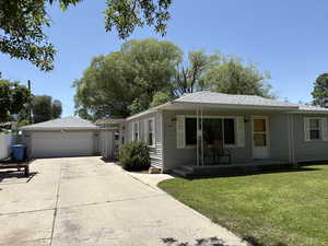 View of front of property with a porch, a garage, a front lawn, concrete driveway, and a shingled roof