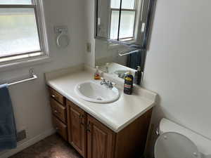 Half bathroom featuring healthy amount of natural light and vanity